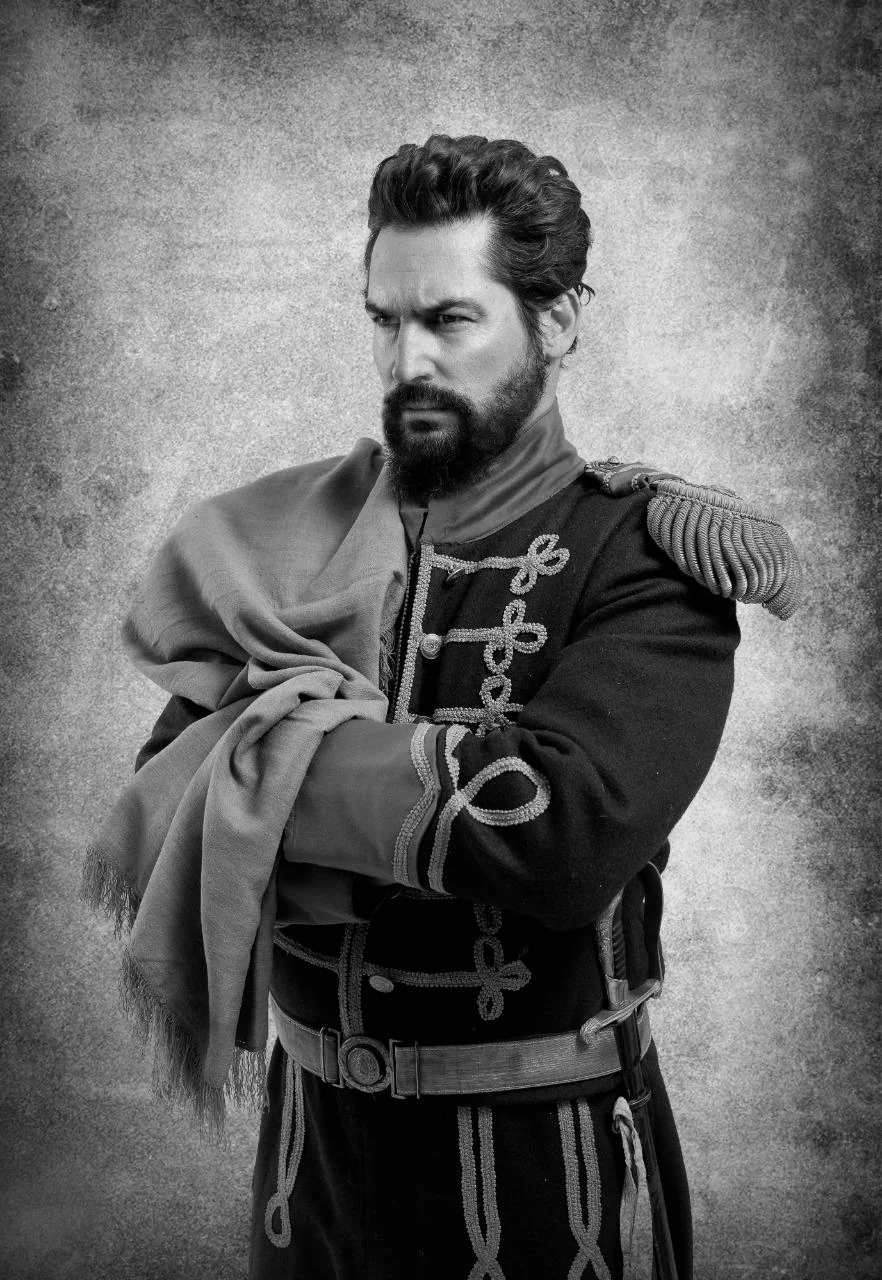 Nacho Valenti Lacroix as General Martín Miguel de Güemes, in uniform with epaulettes and a poncho over his arm, black and white