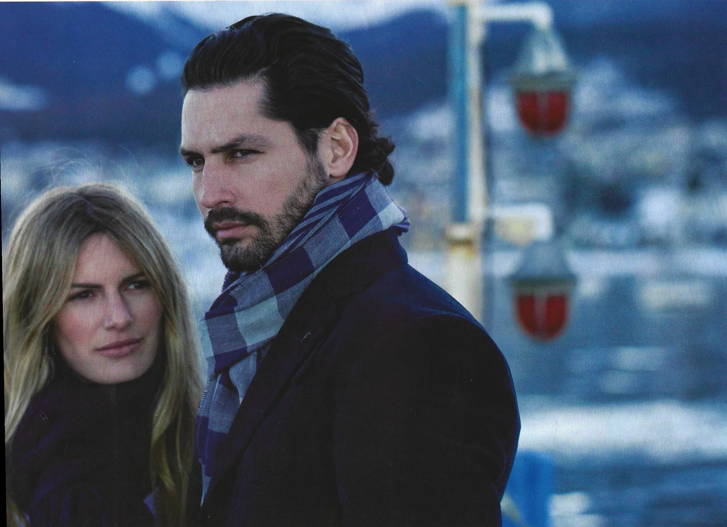 Nacho Valenti Lacroix in a navy coat and checked scarf by a winter lake