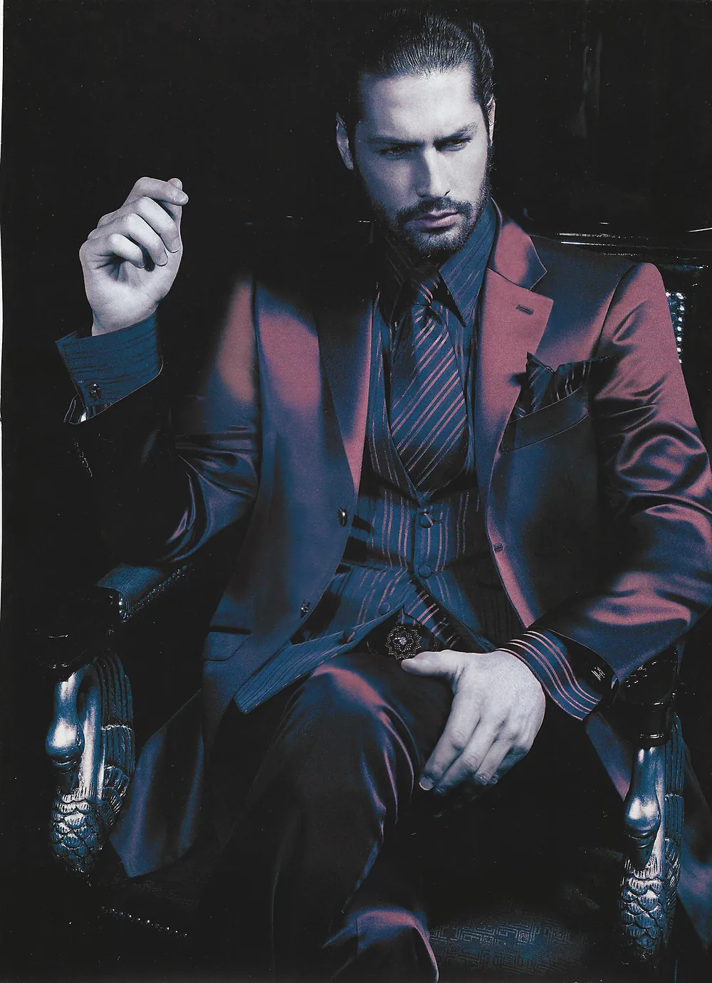 Nacho Valenti Lacroix in a Carlo Pignatelli burgundy suit, seated in a carved chair